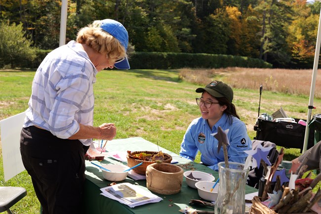 visitor completes art activity with park staff