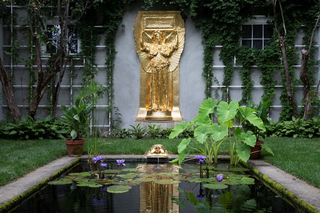 gold-colored statue of angel in open air garden