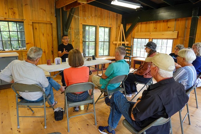 visitors listen to sculptor