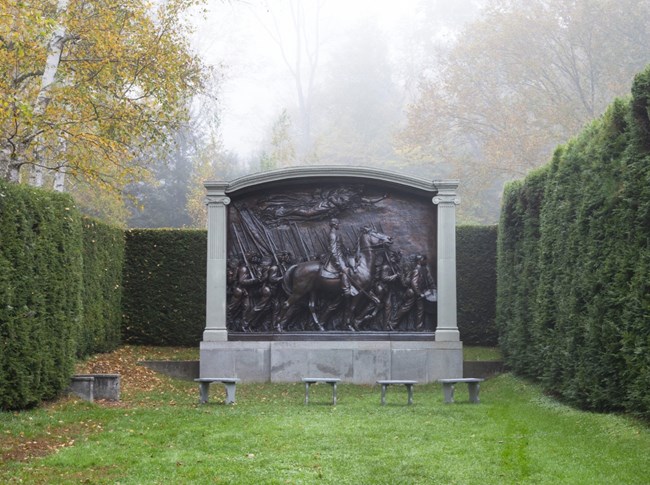 large bronze memorial of civil war general and army of african americans located in hedgerow