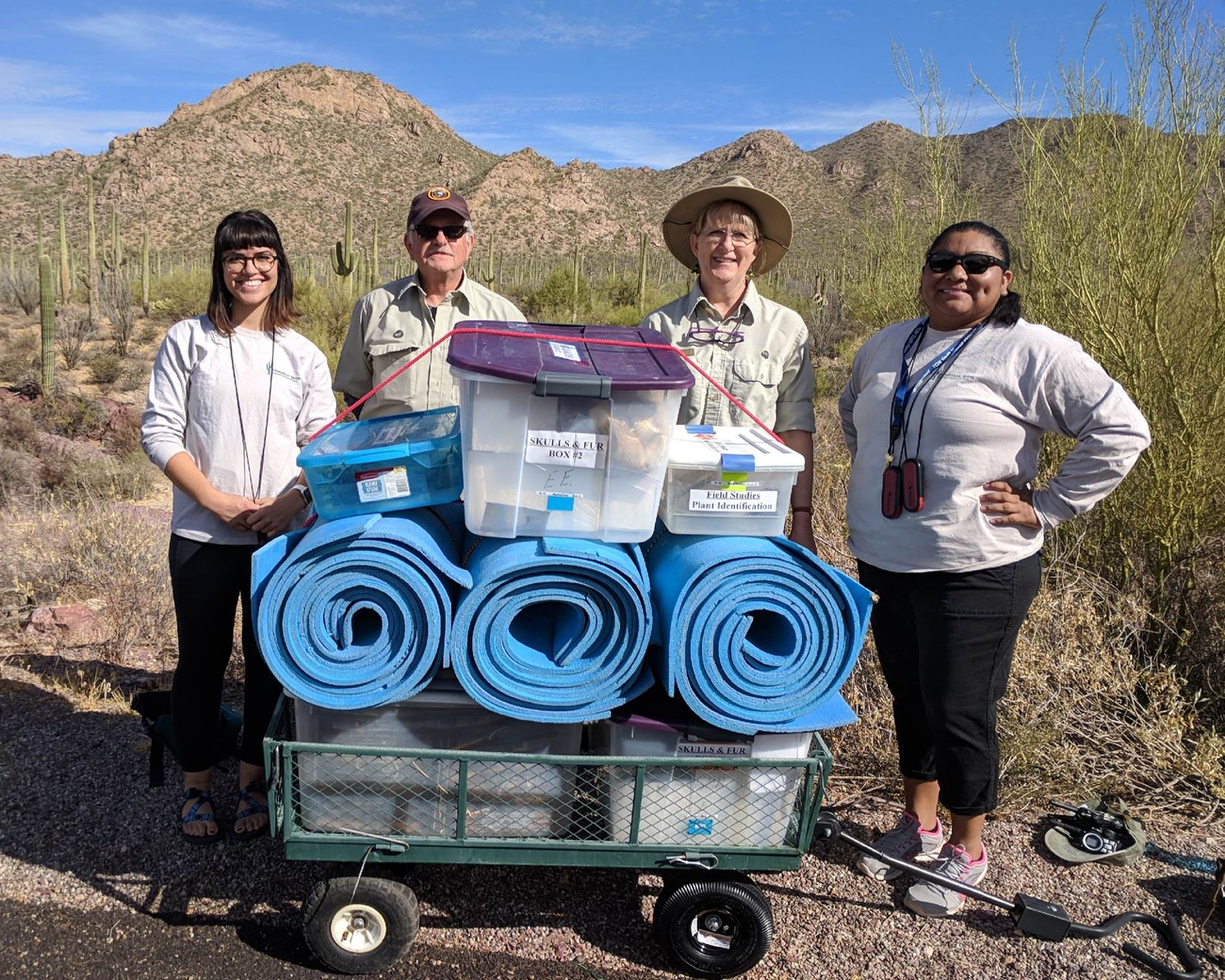 Interns and Volunteers prepare for program. Interns and Volunteers stand in front of a wagon filled with mats and program supplies.