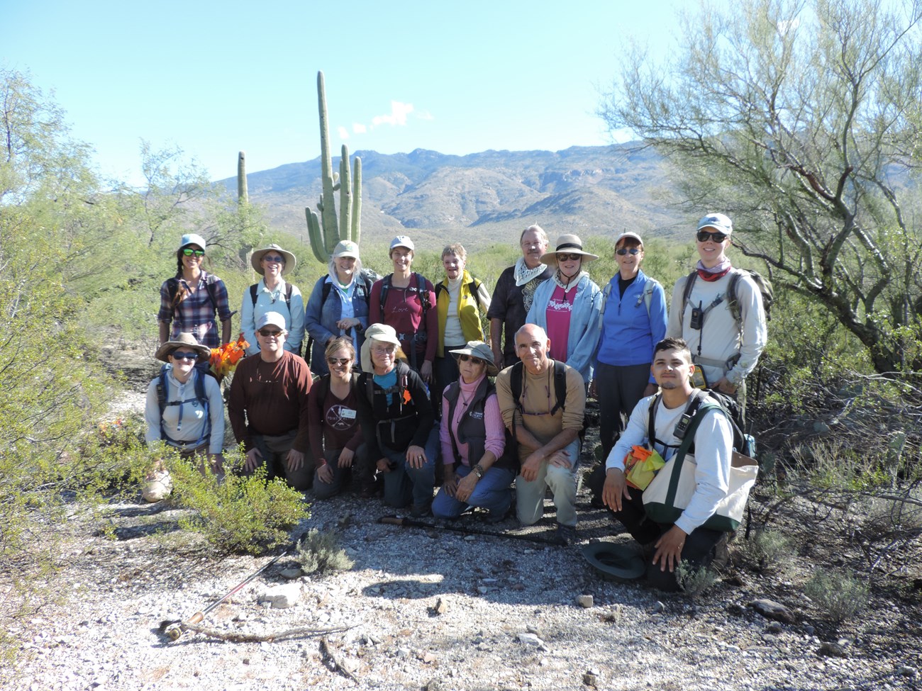 Sky Island Alliance volunteer group photo after the census. Behind them are mountains, saguaros, and lots of vegetation