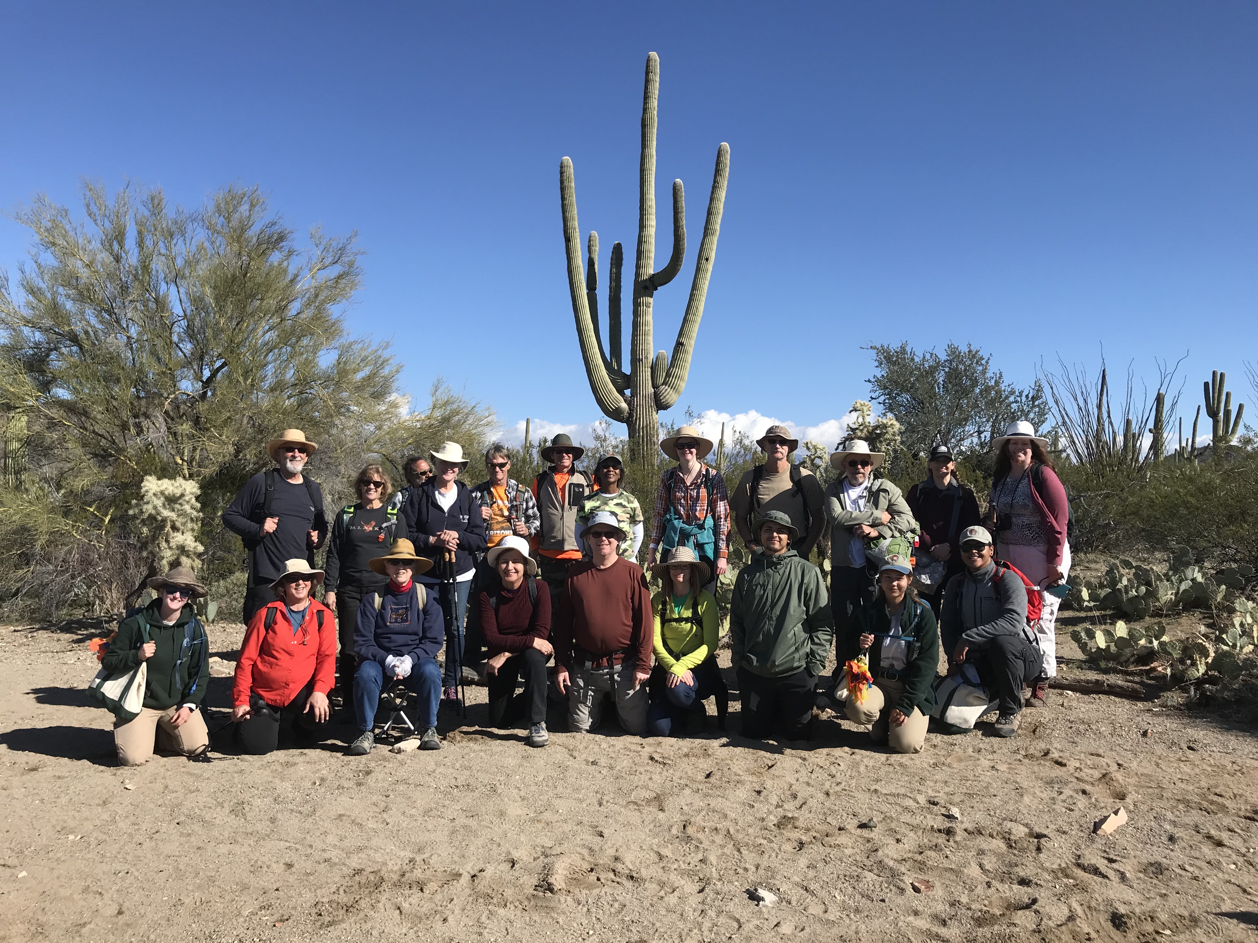 Group photo of volunteers after the census. Behind them is a tall saguaro with at least five arms.