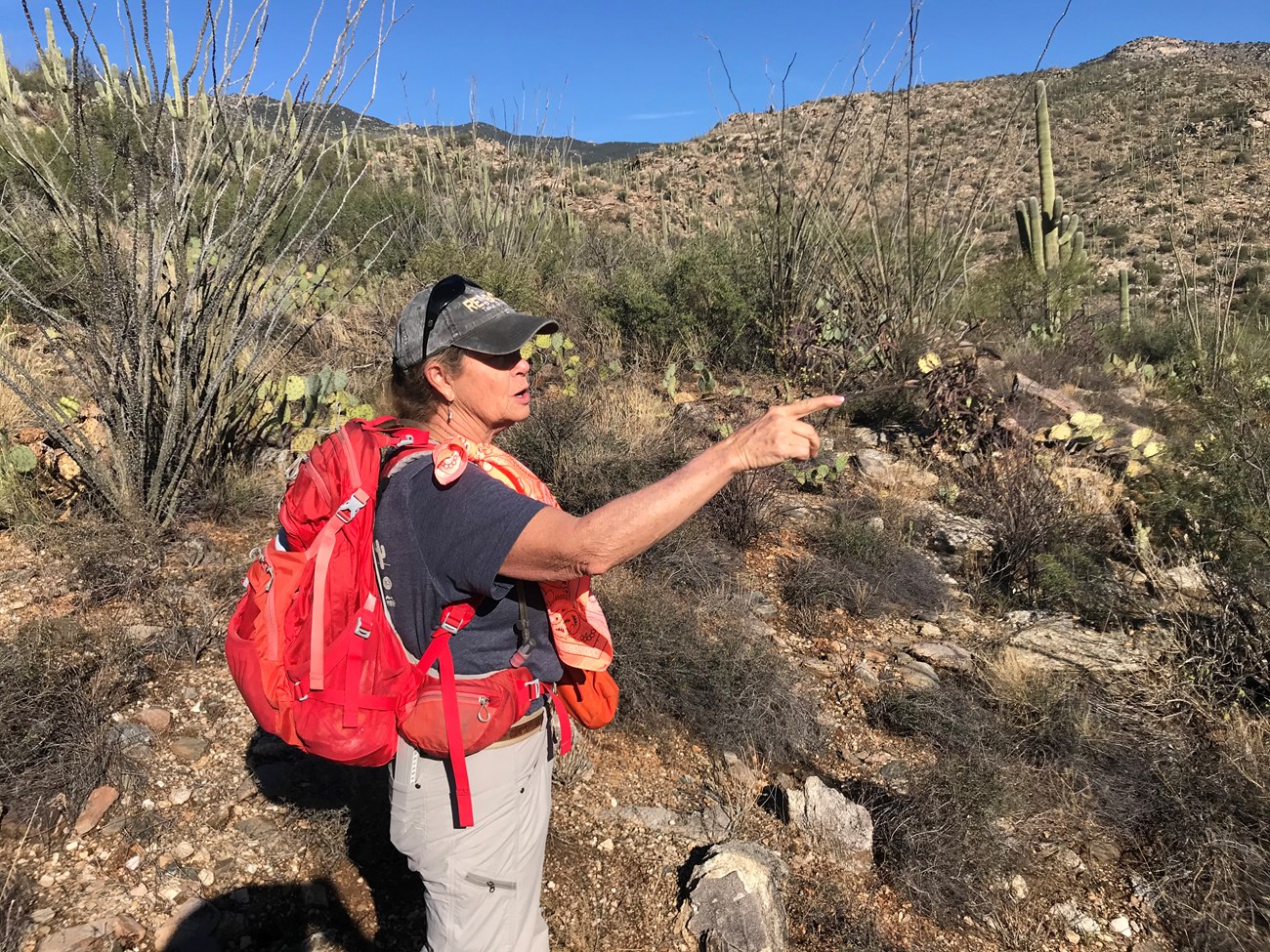 A woman with bright red pack pointing