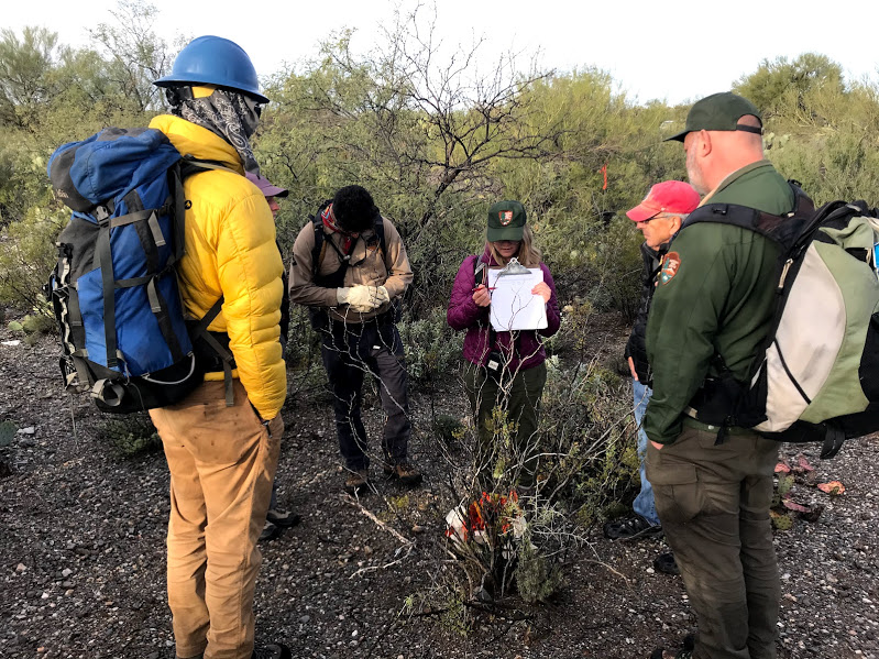 A woman showing to a group of people how to write down data on the data sheet