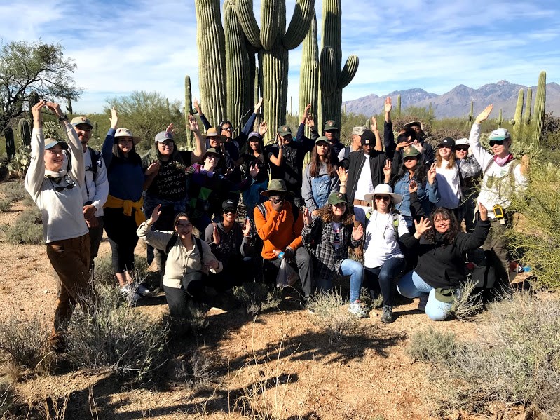 Students, teacher, and park staff posing like a saguaro