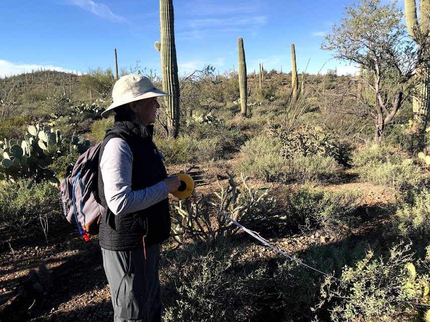 A woman unrolling a measuring tape.