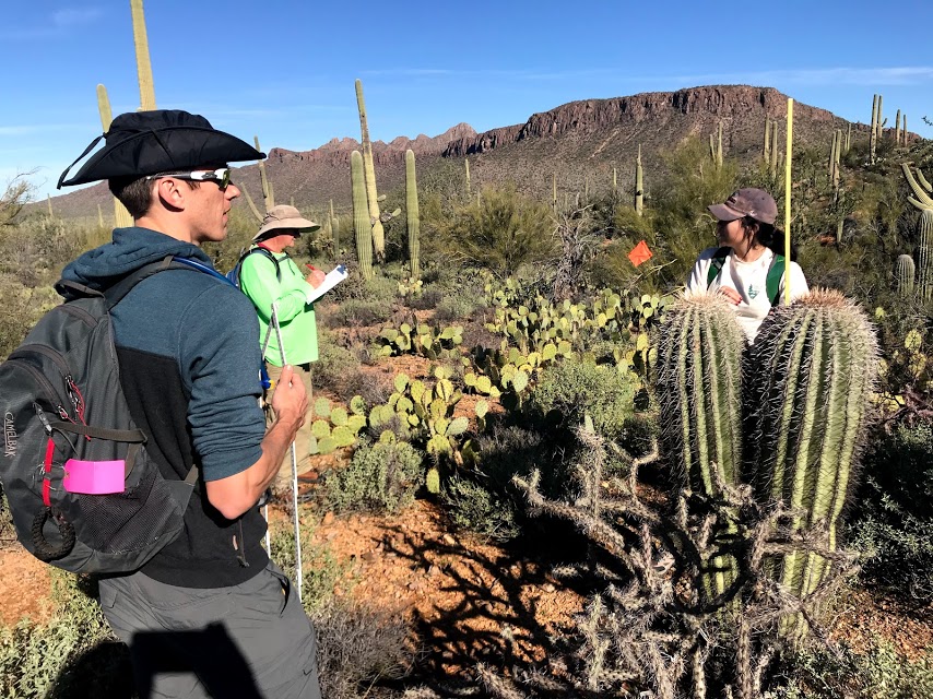 Volunteers working together. One of them is writing down notes on the data sheet.