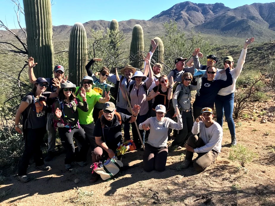 Adventure Scientists and Park Staffs Group photo on the plot after the census. People are posing like a saguaro.