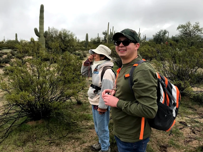 Using a clinometer to figure out the height of a tall saguaro A woman using a clinometer. Next to her is a man smiling to the camera. He is holding another clinometer.