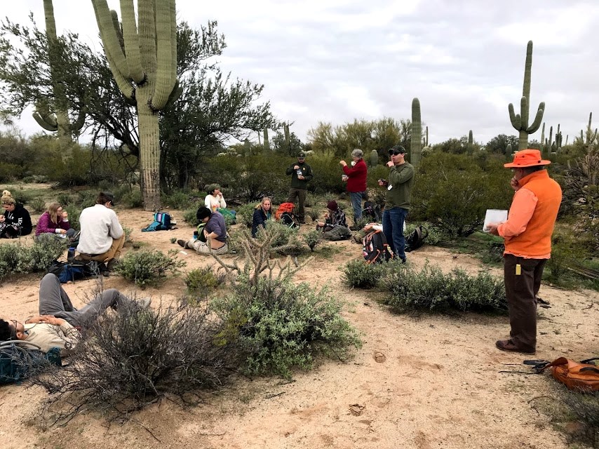Volunteers and park staff on a snack break. They are sitting around the plot.