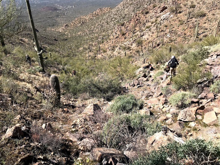 Volunteer navigates rocky desert landscape
