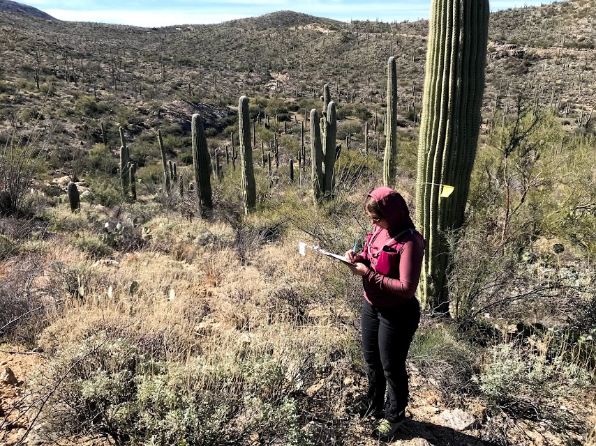 A woman writing on a clipboard.