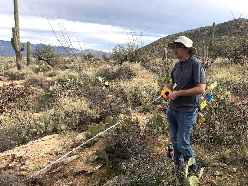 A volunteer holding a tape measure.