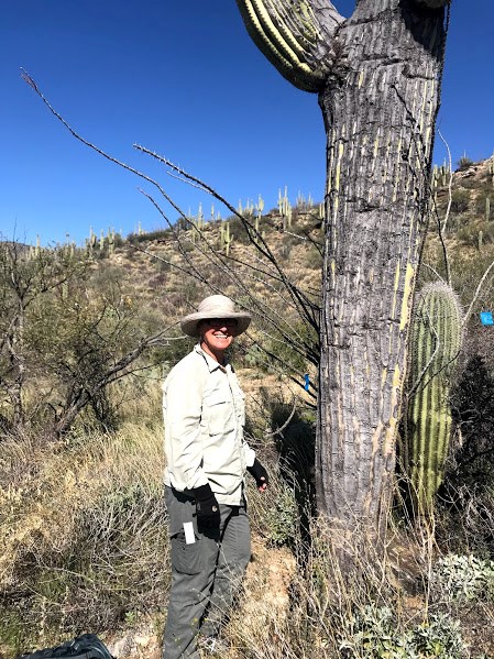 Adventure Scientist smiles with saguaro