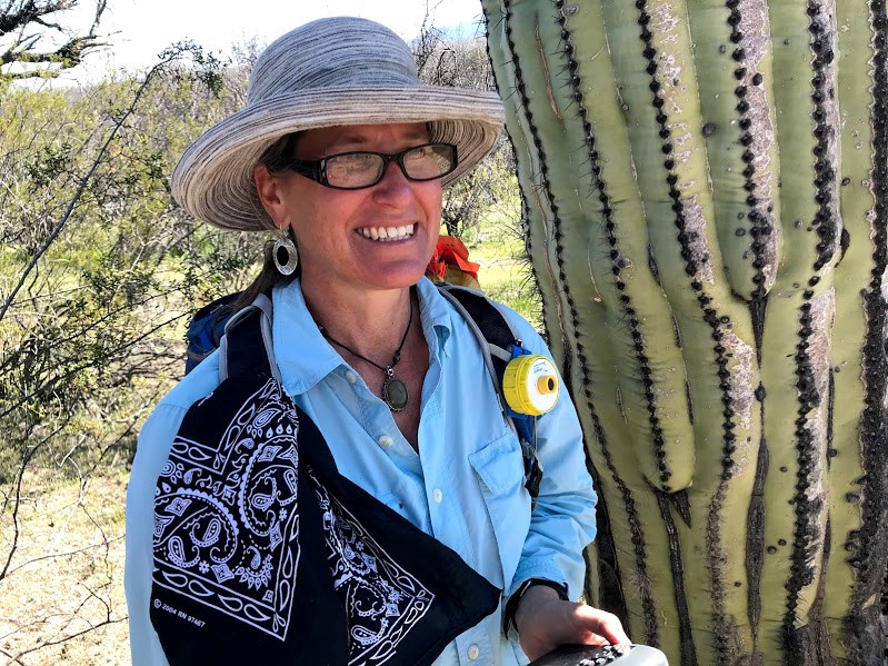 Adventure Scientist smiles with saguaro