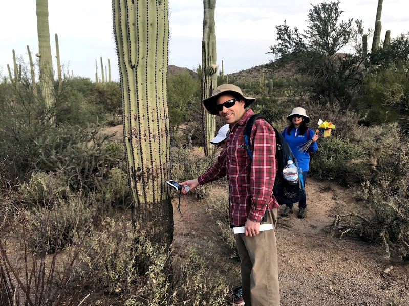 A man finding the coordinates of a saguaro