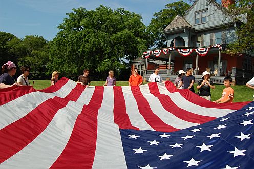 Visitors help fold the flag at Sagamore Hill. Photo Credit: NPS Photo