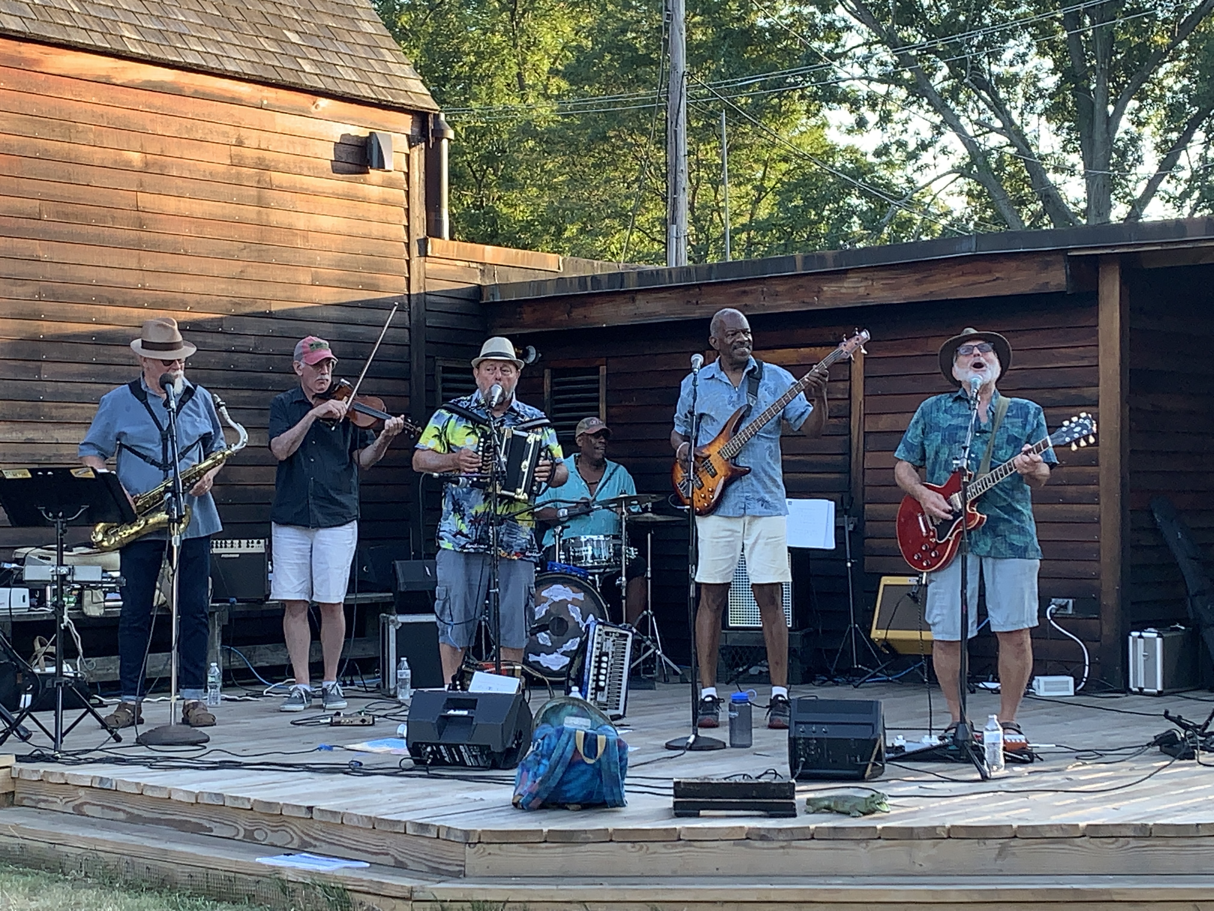 A band featuring eight musicians plays on an outdoor stage