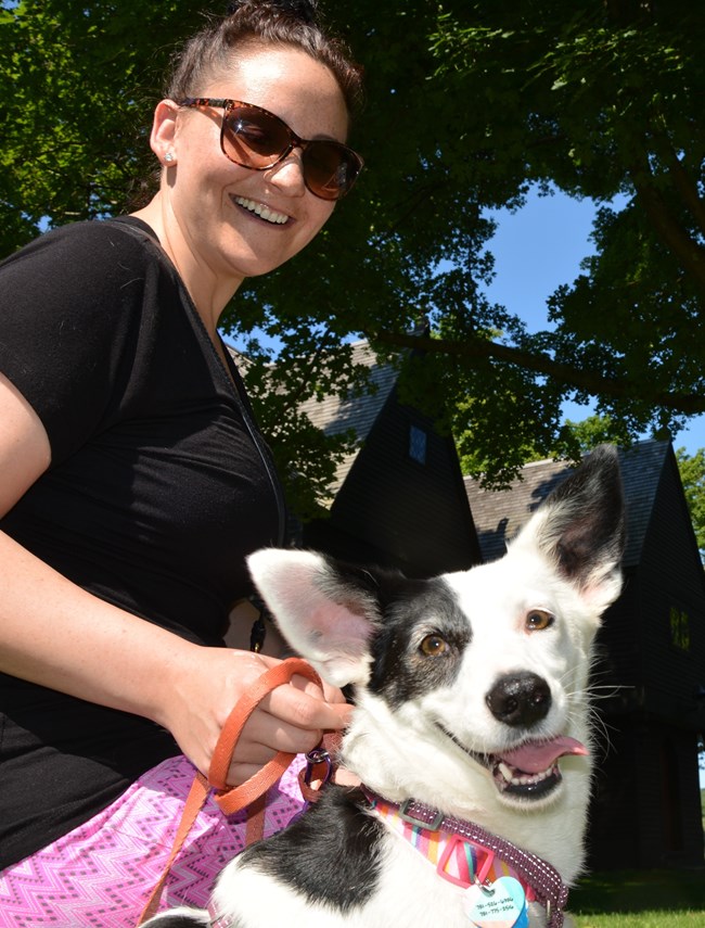 Person sits with small black and white dog