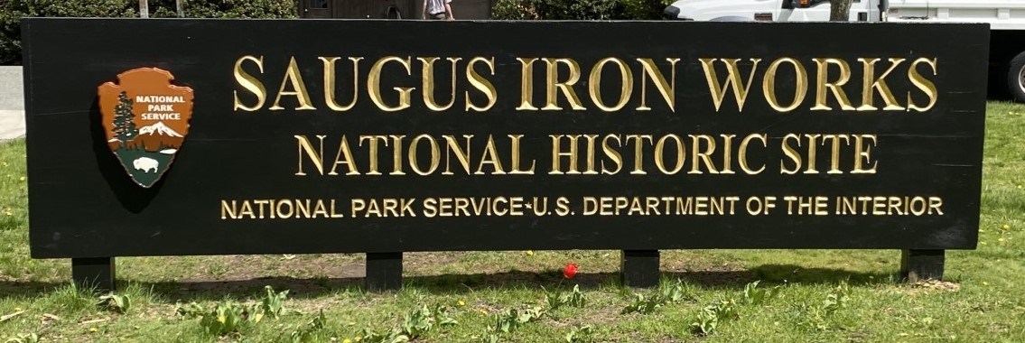 Entrance sign with brown arrowhead and name Saugus Iron Works National Historic Site