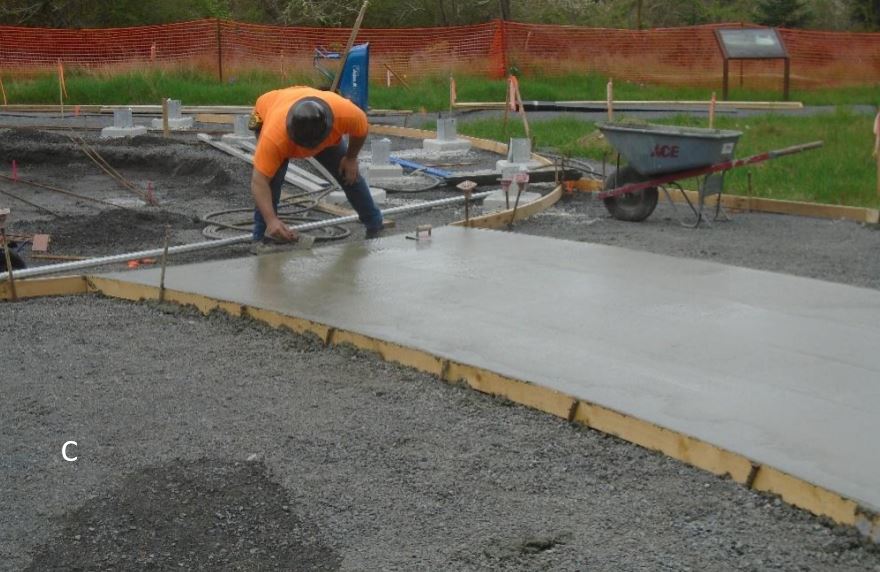 Interpretive Walkway Pour Worker finishing concrete on interpretive walkway
