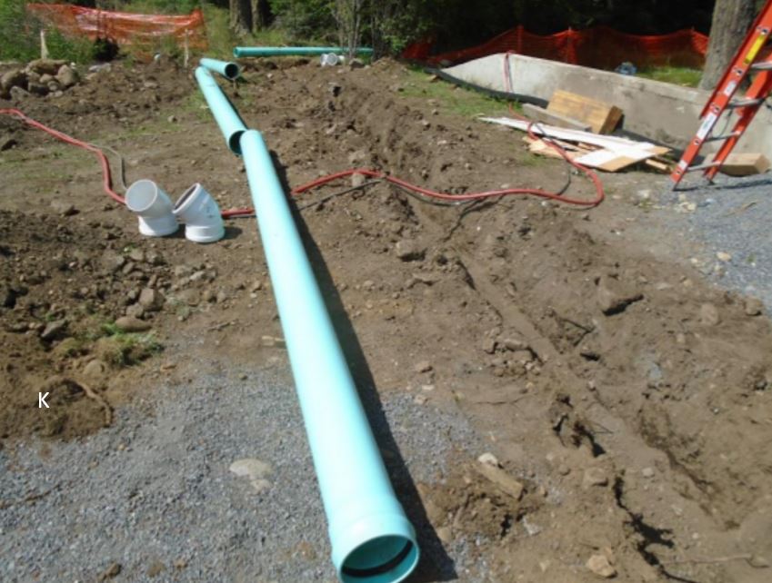 Storm perimeter pipes readied for installation Photo showing green drainage pipe being readied for instal