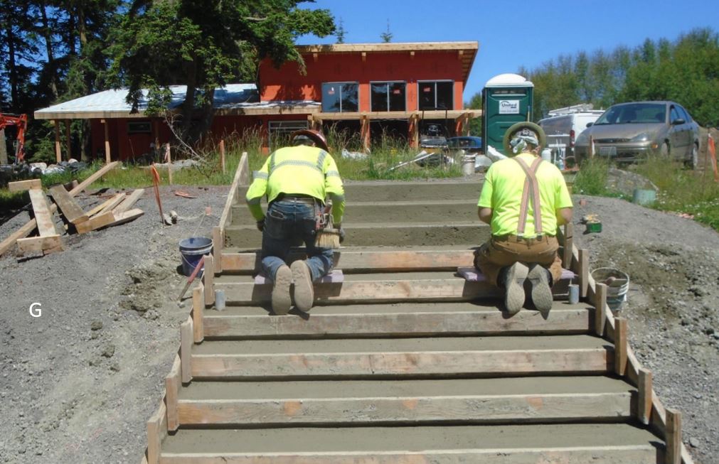 Workers finishing concrete parking lot steps Workers finishing concrete parking lot steps