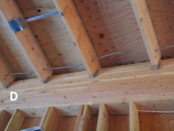 View of metal conduit installed between rafters