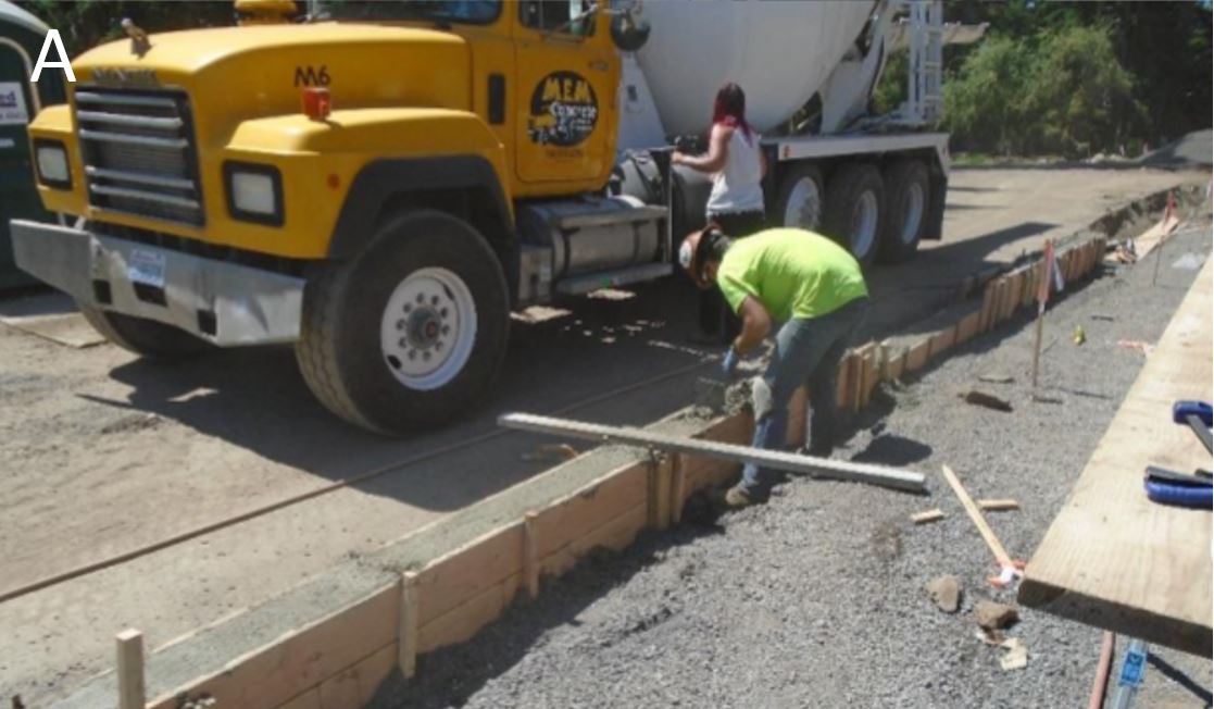 Worker finishing concrete for a curb
