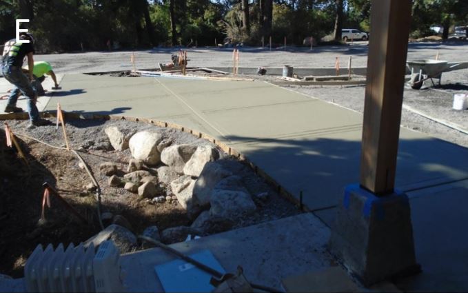 Workers finishing final concrete pours at entry plaza