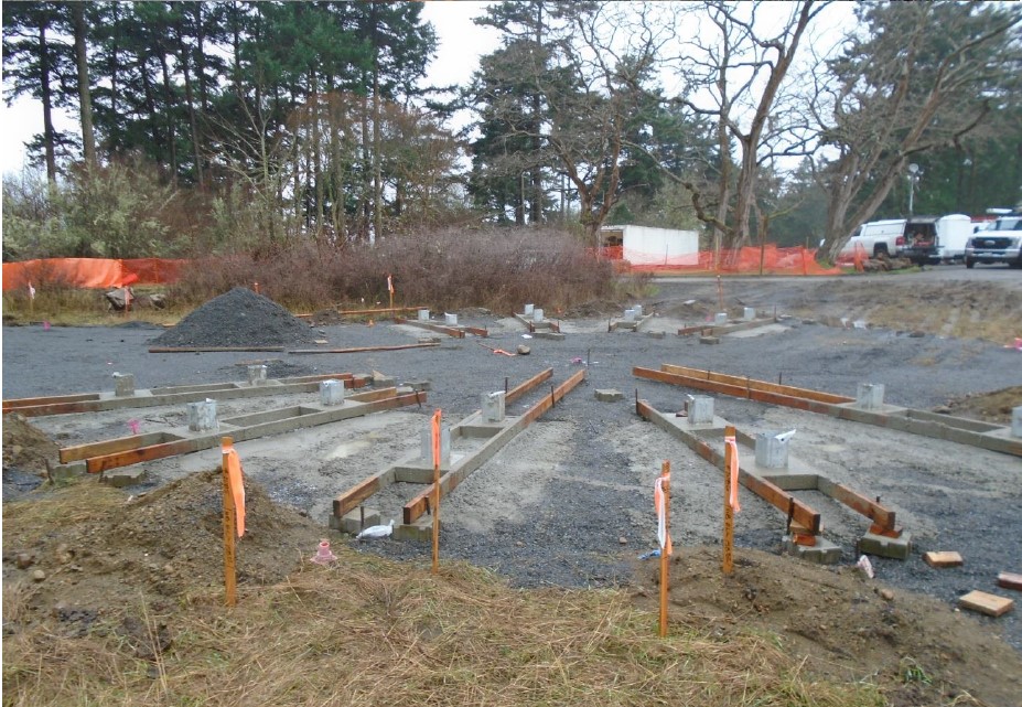 A large circular graveled area has wooden frames for a trellis support in a radial design for concrete pouring