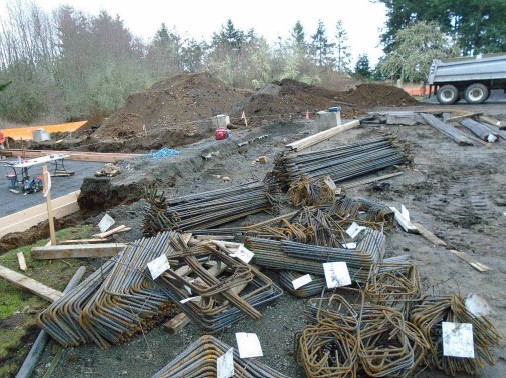 Piles of various shaped and sized reinforcing steel bars are piled at the construction site waiting to be installed.