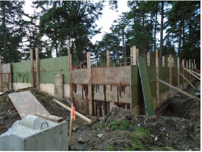 Tallest section of a temporary wood frame is constructed to the leveled height around reinforcing steel for another cement pour