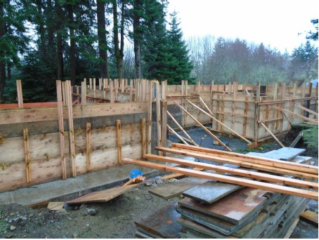 Wooden panels and boards along the building perimeter are used to construct cement formwork for the building’s foundation.