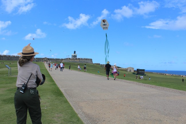 Park ranger flies kite on esplanade of San Felipe del Morro