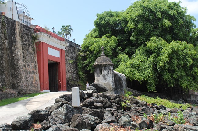 The San Juan Gate with sentry box on the right and the El Paseo Trail in front