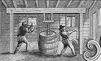two men are using a screw press to put the top on a barrell two men are using a screw press to put the top on a barrell