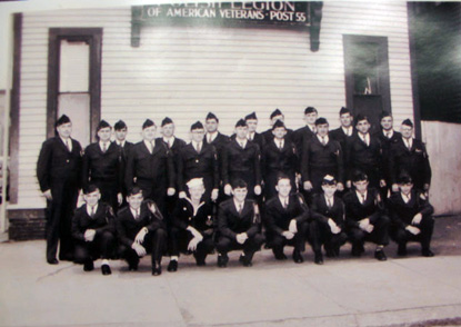 A formal portrait of men in uniform outside a building