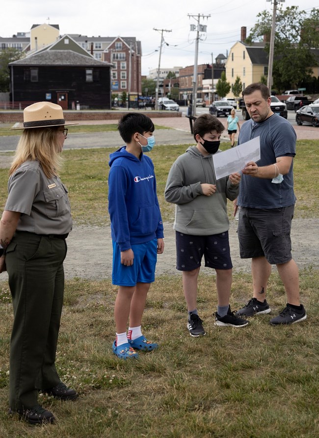 Students and adult examine a document together.