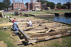 The frames of the building are laid out on the ground to be reassembled