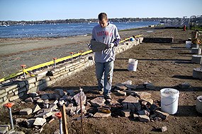 An NPS contractor moving stones