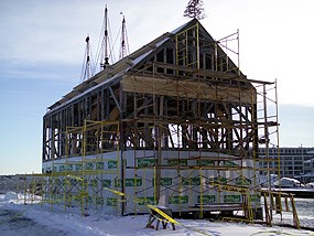the skeleton of Pedrick Store House being wrapped for protection from the elements