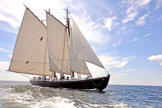 A wooden sailing ship on the open ocean.