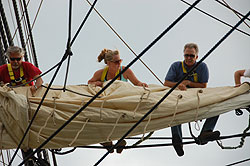 Volunteers furling a sail on Friendship