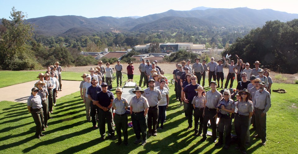 National Park Service staff stand in the shape of the numbers 100