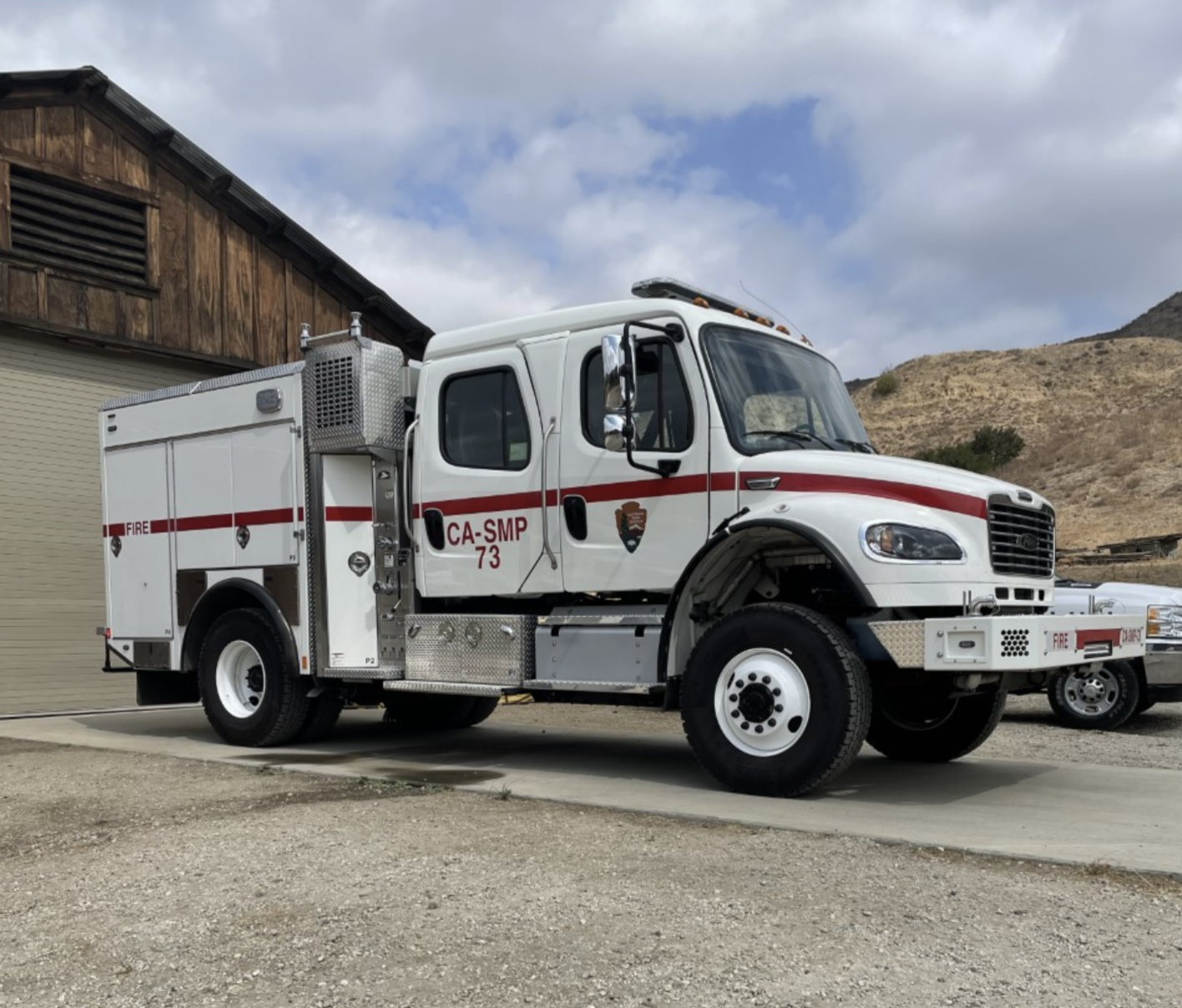 White firetruck parked in a concrete driveway.