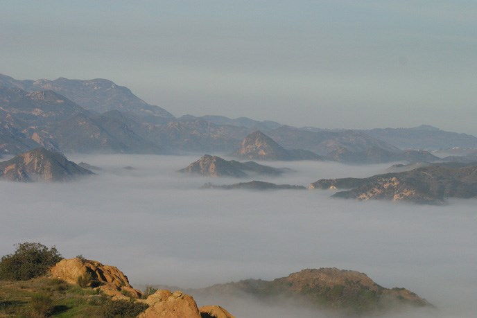 Natural clouds resting below towering mountains