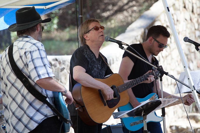 Three men playing their guitars.