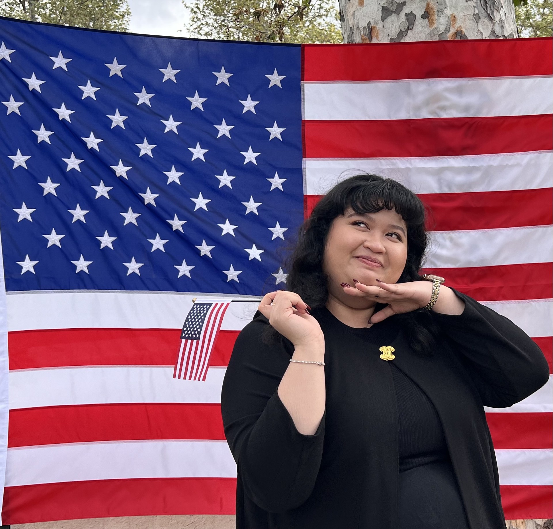 Naturalization_April2024_8 Woman posing in front of flag